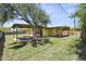 Exterior view of the house from the backyard, featuring a large tree, covered patio, and expansive lawn at 5815 N 10Th Pl, Phoenix, AZ 85014