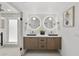 Modern bathroom with double sinks, wooden cabinets, stylish mirrors, and a glass enclosed shower at 5815 N 10Th Pl, Phoenix, AZ 85014