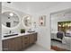 Modern bathroom with double sinks, wooden cabinets, stylish mirrors, and a view into the bedroom at 5815 N 10Th Pl, Phoenix, AZ 85014