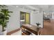 Home office with a wooden desk, a large plant, and view through the sliding door to outdoor patio at 5815 N 10Th Pl, Phoenix, AZ 85014