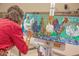 A vibrant painting featuring colorful chicken illustrations in an artist's studio or creative space at 6767 E Nightingale Star Cir, Scottsdale, AZ 85266