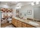 Bathroom featuring a double sink vanity with granite countertop and a patterned shower curtain at 6767 E Nightingale Star Cir, Scottsdale, AZ 85266