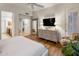 Bedroom featuring hardwood floors, dresser with television, and access to a private balcony at 6767 E Nightingale Star Cir, Scottsdale, AZ 85266