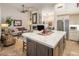 Open-concept kitchen featuring a large island, seamless transition to living area with fireplace at 6767 E Nightingale Star Cir, Scottsdale, AZ 85266