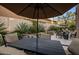 Charming backyard patio with umbrella-covered dining area and lush landscaping at 6767 E Nightingale Star Cir, Scottsdale, AZ 85266