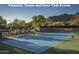 Well-maintained tennis court with lush greenery and scenic mountain views at 6767 E Nightingale Star Cir, Scottsdale, AZ 85266