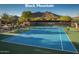 Well-maintained tennis court with clear blue surface, net, and scenic mountain backdrop at 6767 E Nightingale Star Cir, Scottsdale, AZ 85266