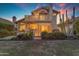 Charming home featuring a backyard with covered patio, balcony, and lush desert landscaping at sunset at 6841 S Roosevelt St, Tempe, AZ 85283