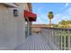 View of the balcony featuring a wooden deck, railings, and a light fixture at 6841 S Roosevelt St, Tempe, AZ 85283