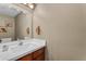 Bathroom with a quartz vanity, decorative mirror and towel holder, and neutral wall paint at 6841 S Roosevelt St, Tempe, AZ 85283