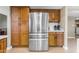 Well-equipped kitchen showcasing wooden cabinets, stainless steel refrigerator, and tiled backsplash at 6841 S Roosevelt St, Tempe, AZ 85283