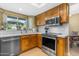 Modern kitchen featuring stainless steel appliances, wood cabinetry, and bright countertops at 6841 S Roosevelt St, Tempe, AZ 85283