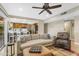 Open-concept living area with kitchen view, neutral sofa, ceiling fan, tile floor, and lots of natural light at 6841 S Roosevelt St, Tempe, AZ 85283