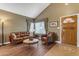 Inviting living room featuring a leather sofa, hardwood floors, vaulted ceiling and entry door at 6841 S Roosevelt St, Tempe, AZ 85283