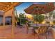 Charming patio with dining set and lounge chair under warm string lights at dusk at 6841 S Roosevelt St, Tempe, AZ 85283