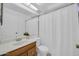 Bathroom showcasing a single sink vanity, standard toilet, and a shower with a white curtain at 7114 W Yucca St, Peoria, AZ 85345