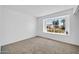 Bright bedroom features neutral carpet, white walls, and a window offering neighborhood views at 7114 W Yucca St, Peoria, AZ 85345