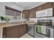 Cozy kitchen featuring stainless steel appliances, neutral countertops, and brown cabinets at 7114 W Yucca St, Peoria, AZ 85345