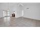 Spacious living room featuring neutral tile flooring, high ceilings, a ceiling fan and sliding glass door to the backyard at 7114 W Yucca St, Peoria, AZ 85345