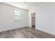 Minimalist bedroom with wood-look flooring and a bright window, offering a clean and inviting atmosphere at 716 W Blue Ridge Dr, San Tan Valley, AZ 85140