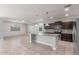 Bright kitchen with dark cabinetry, stainless appliances, granite countertops, tile floors, pendant lighting, and open to living area at 716 W Blue Ridge Dr, San Tan Valley, AZ 85140