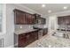Kitchen featuring stainless appliances, dark wood cabinets, granite counters, recessed lighting, pantry, and tile floors at 716 W Blue Ridge Dr, San Tan Valley, AZ 85140