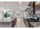 Bright kitchen with dark cabinetry, stainless appliances, granite countertops, and view to living room at 716 W Blue Ridge Dr, San Tan Valley, AZ 85140