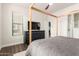 Bright bedroom featuring a four-poster bed, dark wood floors, dresser, and ensuite bathroom at 7445 E Eagle Crest Dr # 1145, Mesa, AZ 85207
