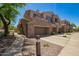 Beautiful multi-level townhome featuring stone accents, a private balcony, and attached garage with desert landscaping at 7445 E Eagle Crest Dr # 1145, Mesa, AZ 85207