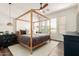 Serene main bedroom with four poster bed, neutral decor, and ample natural light, creating a relaxing retreat at 7445 E Eagle Crest Dr # 1145, Mesa, AZ 85207