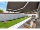 Serene backyard with artificial grass, awning, and stylish tiled patio area offering comfort and relaxation at 7643 E Rancho Vista Dr, Scottsdale, AZ 85251