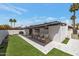 Beautiful backyard featuring artificial grass, tiled patio with seating, and mature palm trees for a serene setting at 7643 E Rancho Vista Dr, Scottsdale, AZ 85251