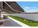 Inviting backyard with artificial grass, awning, and tiled patio perfect for outdoor living and relaxation at 7643 E Rancho Vista Dr, Scottsdale, AZ 85251