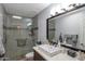 Bathroom featuring a glass shower, stone floors, and a marble-style sink at 7643 E Rancho Vista Dr, Scottsdale, AZ 85251
