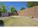 Large grassy backyard with mature trees and a storage shed, fully enclosed with a privacy wall at 768 E Mountain Sky Ave, Phoenix, AZ 85048