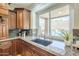 Kitchen sink with granite countertops and a view of the backyard pool and waterfall at 768 E Mountain Sky Ave, Phoenix, AZ 85048