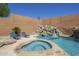 Beautiful pool area featuring a rock waterfall, spa, and two lounge chairs for relaxing at 768 E Mountain Sky Ave, Phoenix, AZ 85048