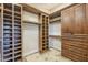 Custom walk-in closet with built-in shelving, cabinets, and tile flooring, providing ample storage space at 768 E Mountain Sky Ave, Phoenix, AZ 85048