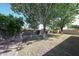 A view of the serene backyard with lush greenery, mature trees, and an outdoor seating area at 8017 W Eugie Ave, Peoria, AZ 85381