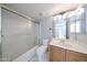 Bathroom featuring tub/shower combo with glass door and vanity with a sink at 8017 W Eugie Ave, Peoria, AZ 85381
