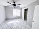 Bright bedroom featuring a ceiling fan, window, tile floor, and a closet with sliding doors at 8017 W Eugie Ave, Peoria, AZ 85381