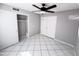 An inviting bedroom with tile flooring, ceiling fan, and closet with sliding doors at 8017 W Eugie Ave, Peoria, AZ 85381