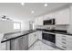 Bright kitchen features black countertops, stainless steel appliances, and white cabinetry at 8017 W Eugie Ave, Peoria, AZ 85381