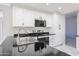 The kitchen is equipped with stainless steel appliances, black counters, and white cabinets at 8017 W Eugie Ave, Peoria, AZ 85381