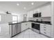 Bright kitchen features black countertops, stainless steel appliances, and white cabinetry at 8017 W Eugie Ave, Peoria, AZ 85381