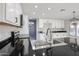 Bright open-concept kitchen features black countertops, and white cabinetry at 8017 W Eugie Ave, Peoria, AZ 85381