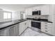 Bright kitchen features black countertops, stainless steel appliances, and white cabinetry at 8017 W Eugie Ave, Peoria, AZ 85381