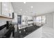 Bright open-concept kitchen features black countertops, and white cabinetry at 8017 W Eugie Ave, Peoria, AZ 85381