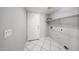 Functional laundry room with tile floors, storage shelves and access door to exterior at 8017 W Eugie Ave, Peoria, AZ 85381