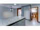 Kitchen with granite island and grey cabinetry and access to the living and laundry rooms at 8220 E Montecito Ave, Scottsdale, AZ 85251